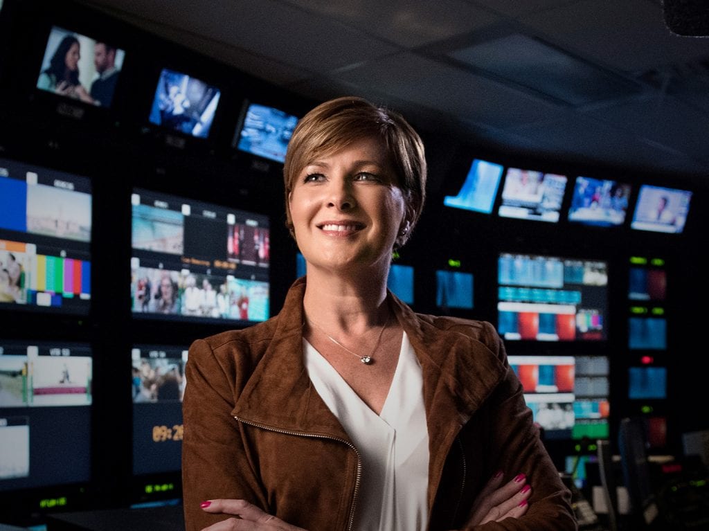 Diana Swain standing in a news broadcasting room.