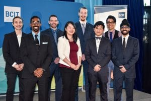 2016 presentation idol finalists standing on a stage in front of a blue background with the BCIT logo on it. The diverse group of students are, from left to right: Aaron Rendina, Sanesh Iyer, Reza Filsoof, Isabella Wong, Dean Tamboline, Arkgo Chen, Kevin Hong, and Judge’s Choice winner Navtej Heir