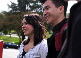 Man and woman smiling as they are facing to the left of the pic.