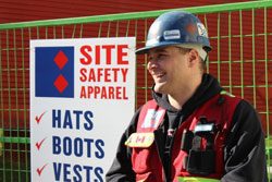 A safety officer at the Site Safety Apparel sign.