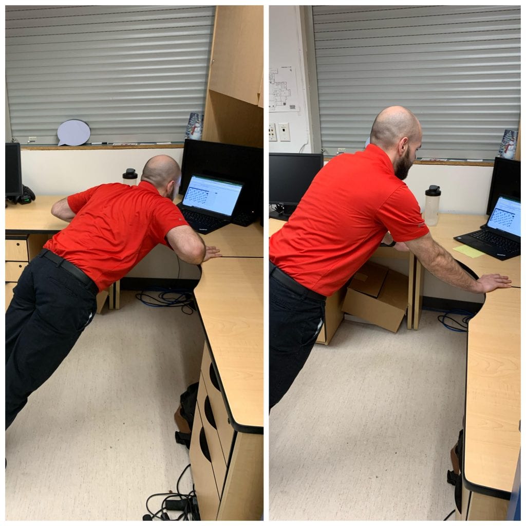 man doing an incline pushup be leaning on a desk