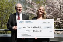 Photo of nicola gardner and another person holding a cheque for 5,000 dollars.