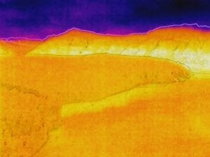 Thermal aerial image of glacier along waterway.