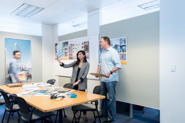 Hero image where you can see 3 people in a workspace discussing a colour palette