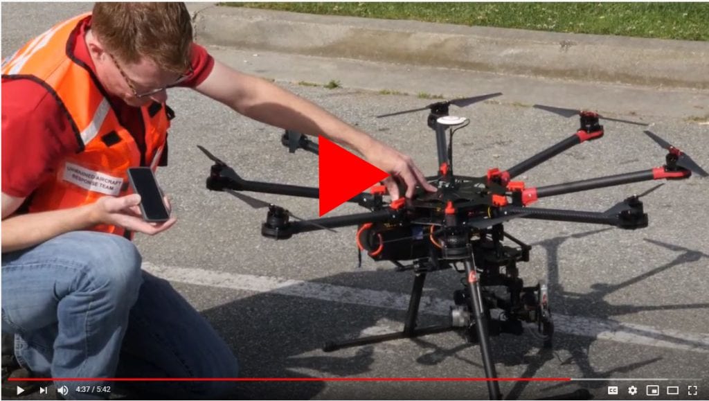 Man in safety vest setting up a drone