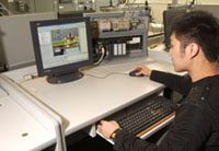 student of asian decent looks at a desktop computer