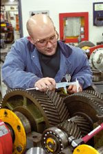 Millwright measuring a set of gears