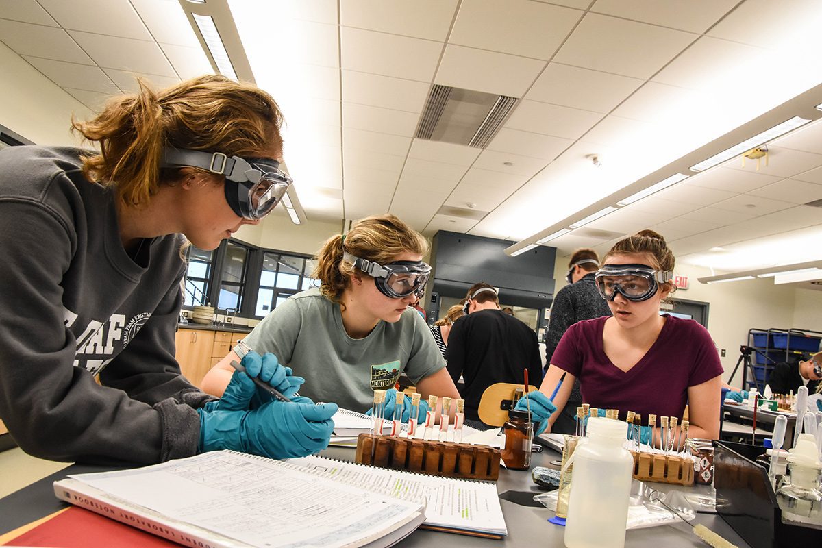 Students in chemistry lab wearing safety glasses.