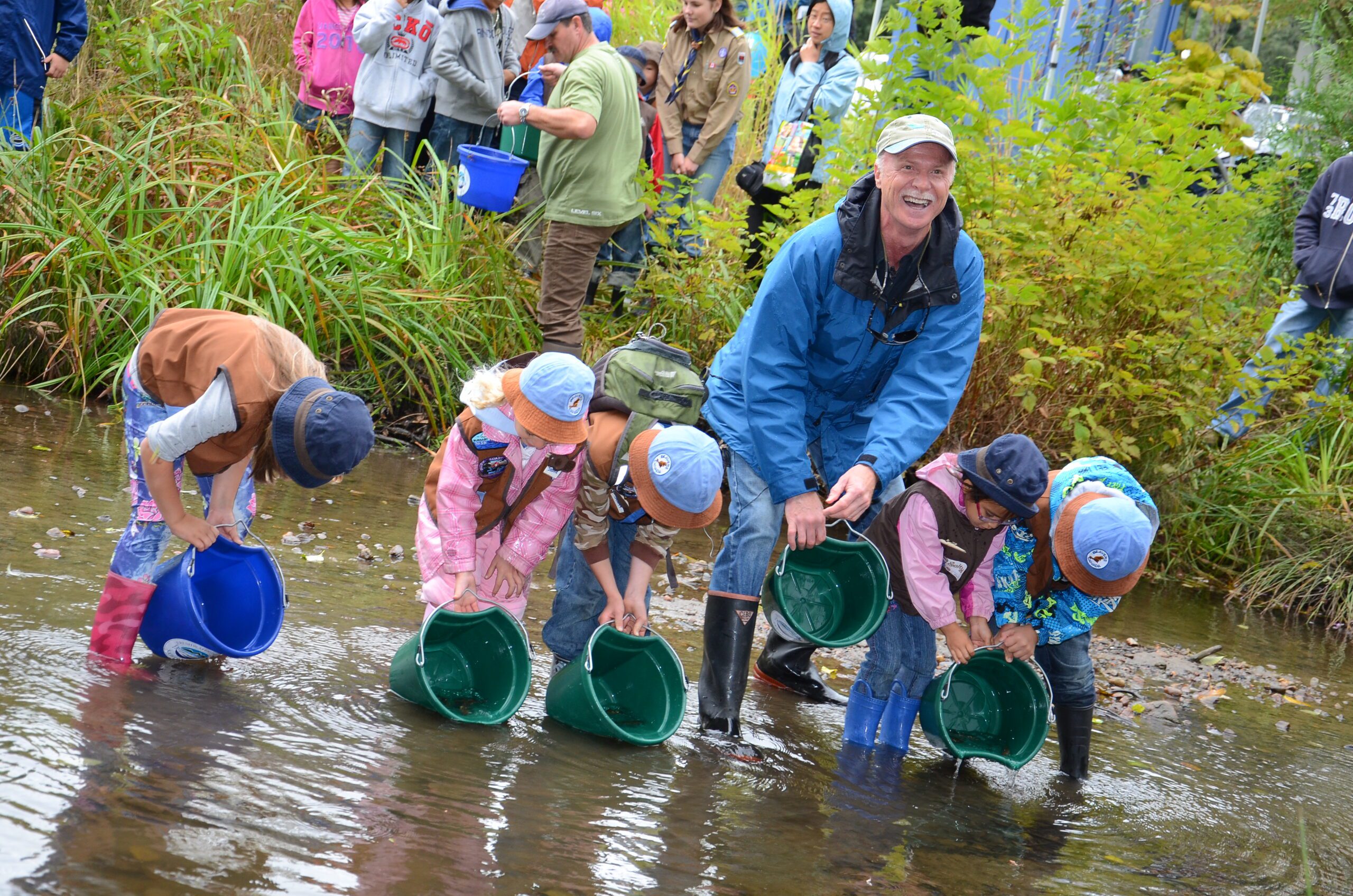 Mark Angelo in a creek looking for salmon with four kids knee deep in water