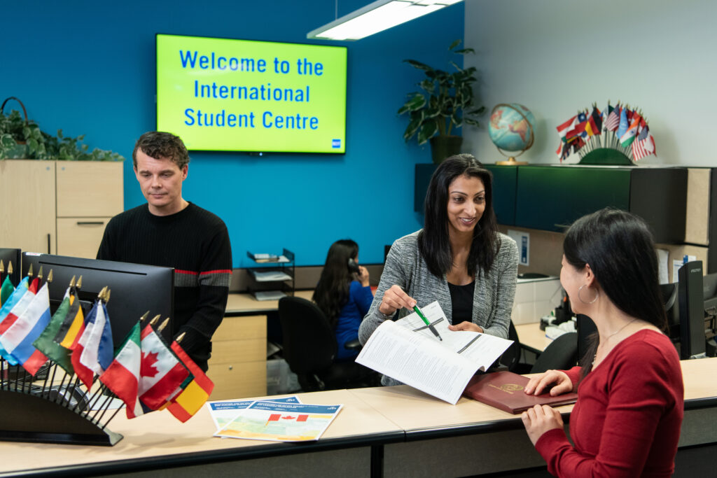 staff members in the International Student Centre assisting a student