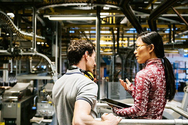 Mechanic And Female Engineer Talking in Factory