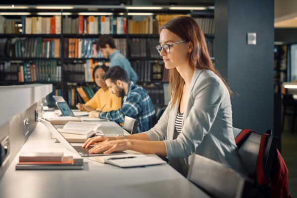 University Library: Talented Caucasian Girl Sitting at the Desk,