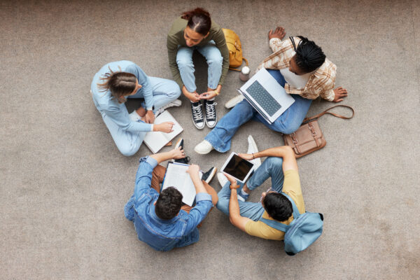 Study, laptop and group of students on floor in project, research or planning, brainstorming and teamwork. Notebook, education and top of university student, friends or people collaboration in school